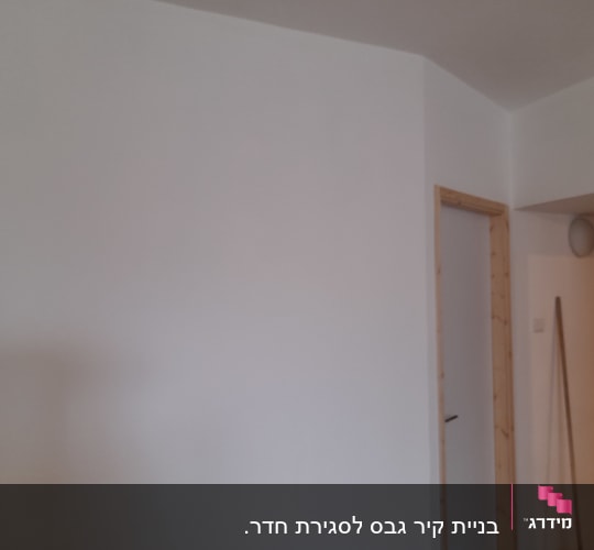 קיר גבס לבן עם דלת עץ